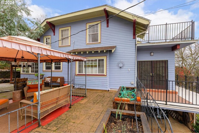 rear view of house featuring a gazebo, an outdoor hangout area, and a patio