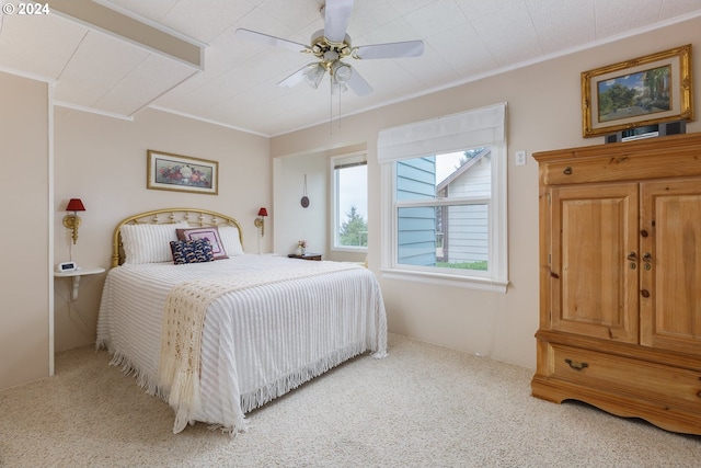 carpeted bedroom with ceiling fan and ornamental molding