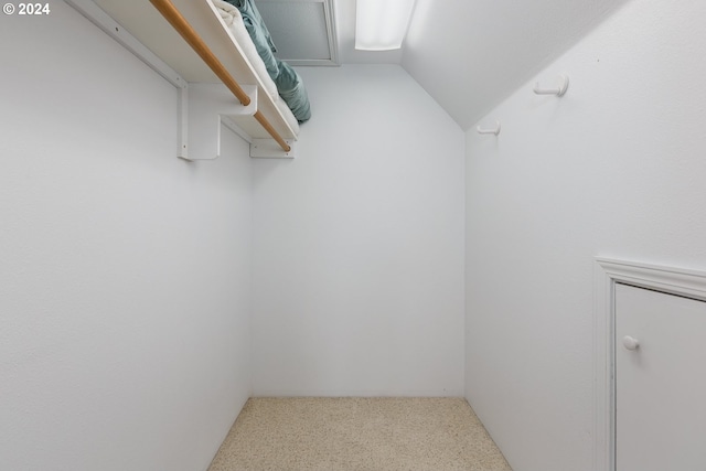 spacious closet featuring carpet flooring and lofted ceiling