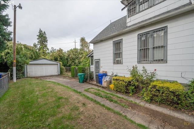 view of home's exterior with a yard, a garage, and an outdoor structure