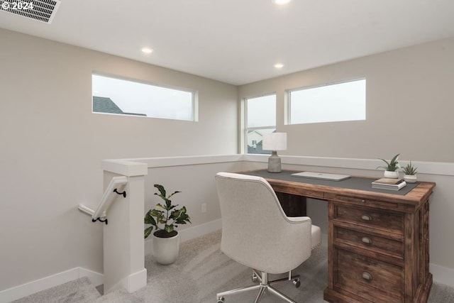 office with light colored carpet and a wealth of natural light