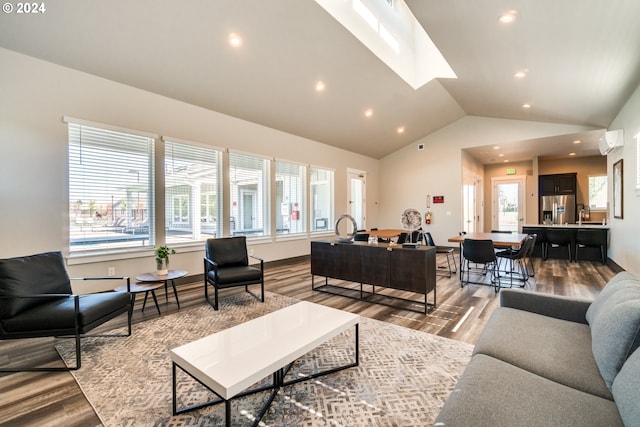 living room with a wall mounted air conditioner, light wood-type flooring, high vaulted ceiling, and sink