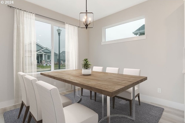 dining space with light wood-type flooring and a chandelier