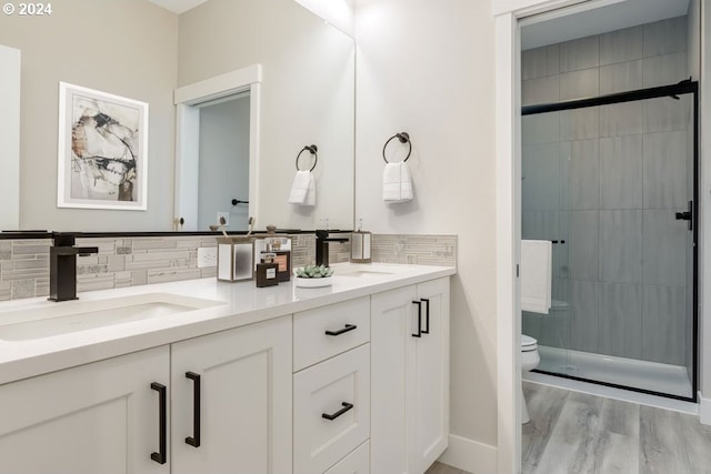 bathroom featuring walk in shower, backsplash, toilet, vanity, and hardwood / wood-style flooring