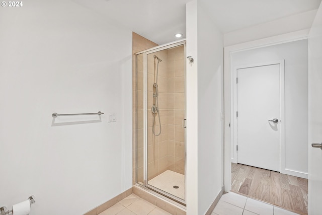 bathroom featuring a shower with door and wood-type flooring