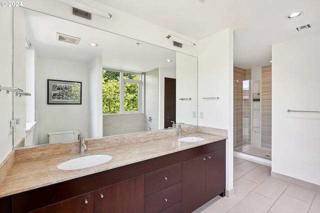 bathroom with vanity, tile patterned floors, toilet, and tiled shower