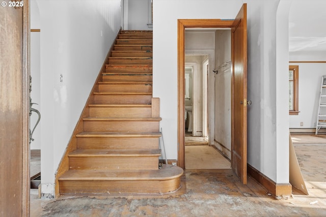 staircase with a baseboard heating unit