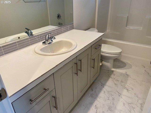 full bathroom featuring bathtub / shower combination, vanity, and toilet