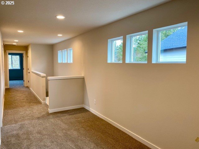 hall with light colored carpet