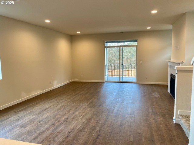 unfurnished living room with dark hardwood / wood-style flooring