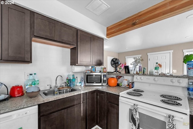 kitchen with dark brown cabinets, white appliances, tasteful backsplash, and sink