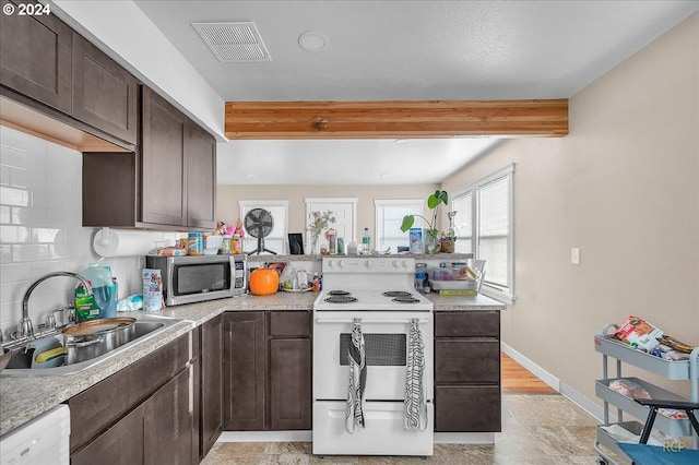 kitchen with backsplash, dark brown cabinetry, sink, and white appliances