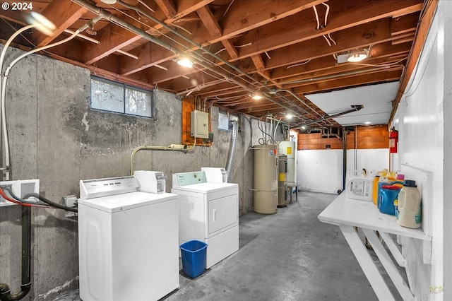 basement featuring water heater, electric water heater, and separate washer and dryer