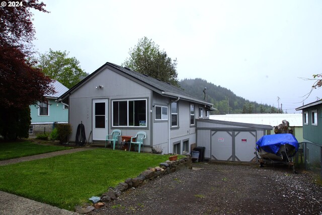 rear view of property with a lawn and a garage