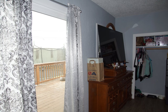 interior space featuring hardwood / wood-style flooring, a textured ceiling, and a closet