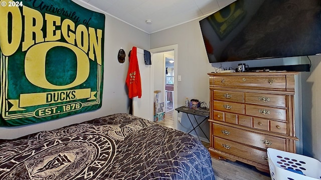 bedroom with wood-type flooring and ornamental molding