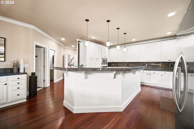 kitchen featuring dark hardwood / wood-style floors, white cabinetry, a breakfast bar area, and stainless steel appliances