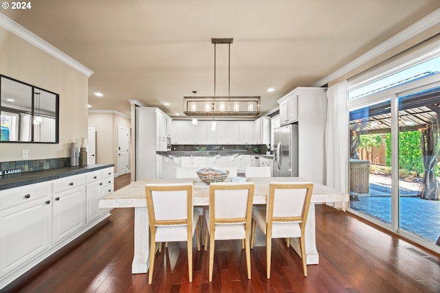 kitchen with stainless steel fridge with ice dispenser, white cabinetry, hanging light fixtures, dark hardwood / wood-style flooring, and ornamental molding