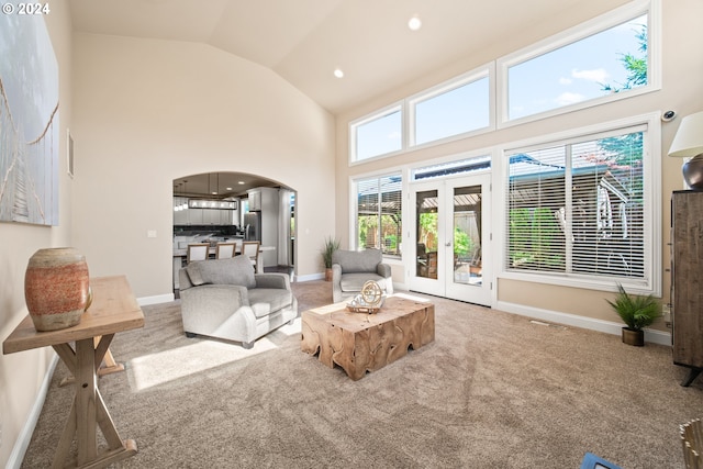 living room with carpet floors, french doors, and high vaulted ceiling