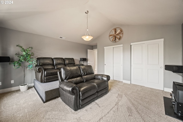 home theater room with vaulted ceiling and carpet