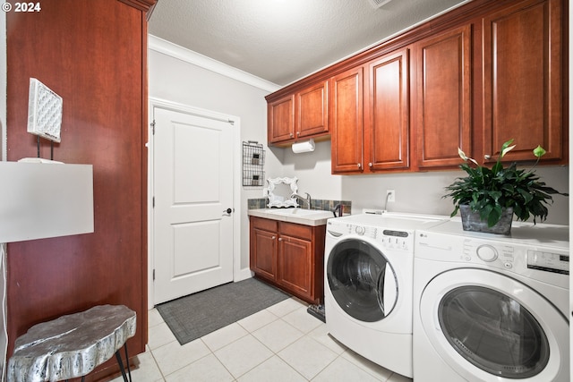 laundry room featuring a textured ceiling, crown molding, cabinets, sink, and washing machine and clothes dryer