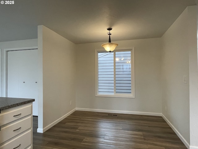 unfurnished dining area with dark hardwood / wood-style flooring