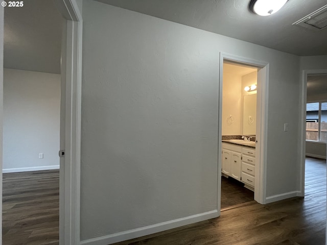 hall featuring dark wood-type flooring and sink