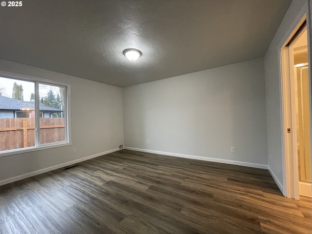 interior space with a textured ceiling and dark hardwood / wood-style flooring