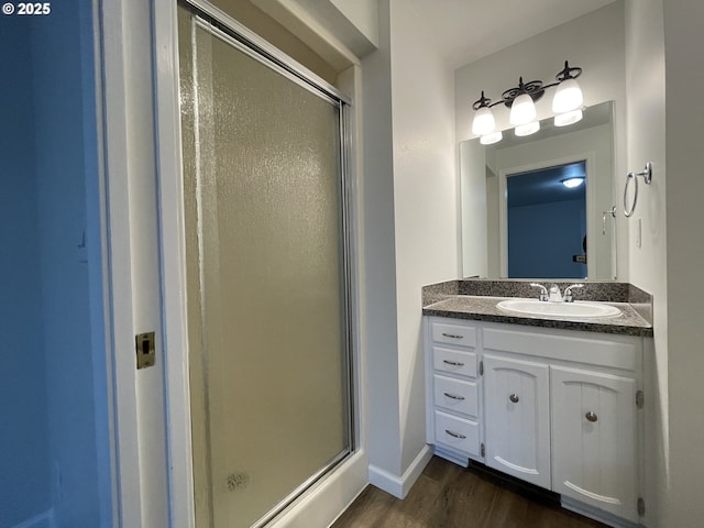 bathroom featuring hardwood / wood-style flooring, an enclosed shower, and vanity