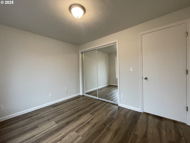 unfurnished bedroom with a closet and dark hardwood / wood-style flooring