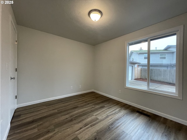 spare room with dark wood-type flooring