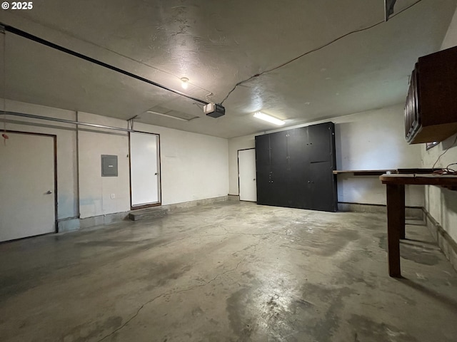 garage featuring electric panel and a garage door opener