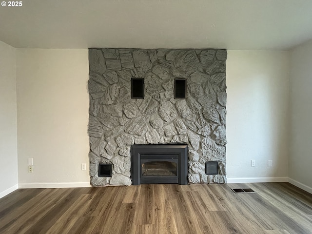 details with a stone fireplace and hardwood / wood-style flooring