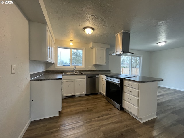 kitchen featuring white cabinetry, island range hood, kitchen peninsula, appliances with stainless steel finishes, and sink