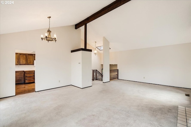 unfurnished living room featuring beam ceiling, high vaulted ceiling, light colored carpet, and an inviting chandelier