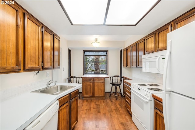 kitchen with light hardwood / wood-style floors, white appliances, and sink