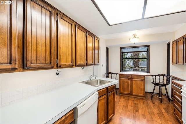 kitchen with hardwood / wood-style flooring, dishwasher, range, and sink