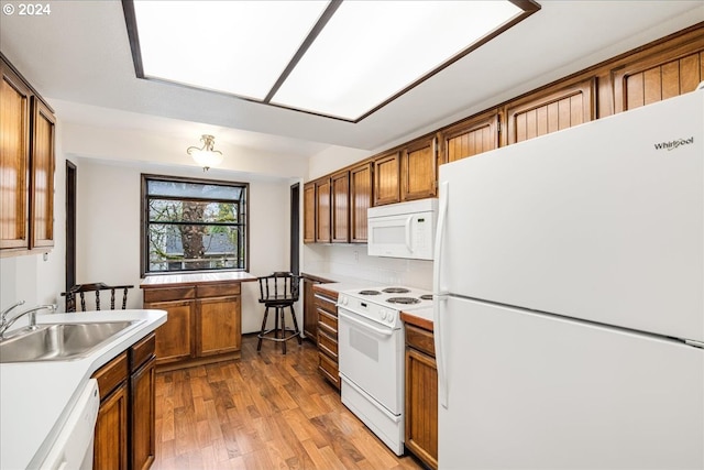 kitchen with white appliances, light hardwood / wood-style flooring, and sink