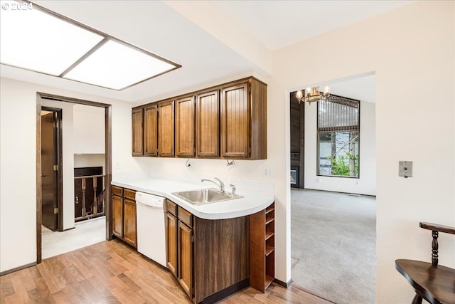 kitchen with light hardwood / wood-style flooring, white dishwasher, an inviting chandelier, and sink