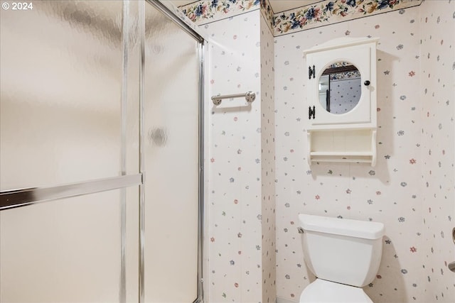 bathroom with toilet and a shower with door