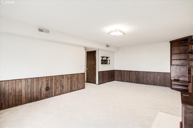 carpeted spare room with wood walls