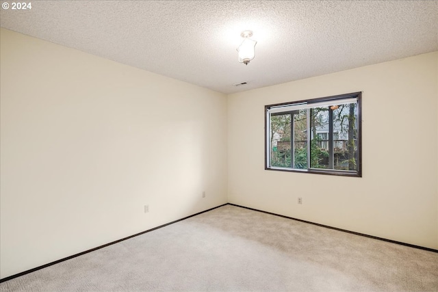 carpeted spare room featuring a textured ceiling