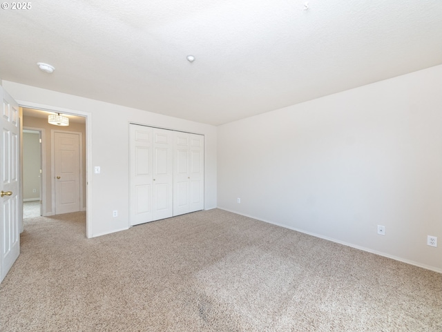 unfurnished bedroom featuring carpet floors, a textured ceiling, and a closet