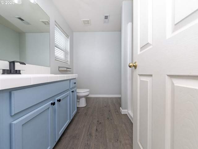 bathroom with hardwood / wood-style flooring, vanity, and toilet