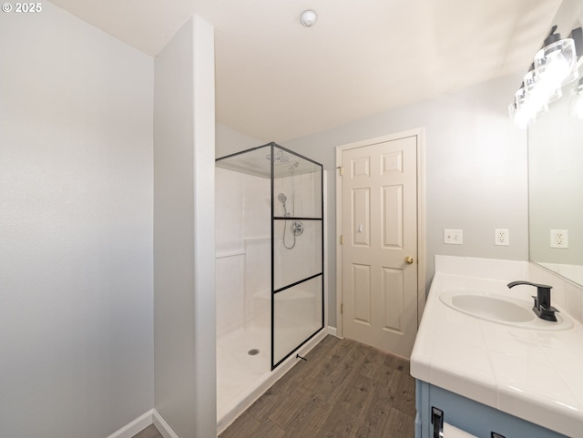 bathroom featuring wood-type flooring, vanity, and a shower with shower door