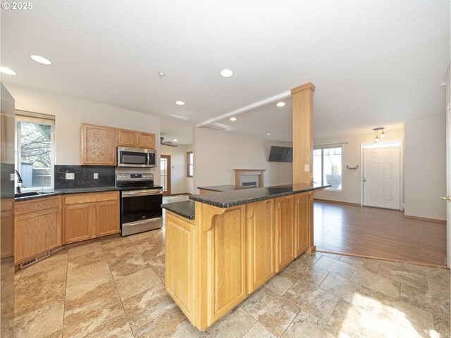 kitchen featuring a breakfast bar, tasteful backsplash, sink, a center island, and stainless steel appliances