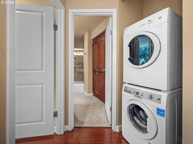 clothes washing area featuring stacked washer and clothes dryer and dark hardwood / wood-style floors