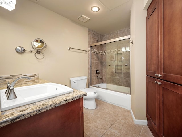 full bathroom featuring tile patterned floors, toilet, combined bath / shower with glass door, and vanity