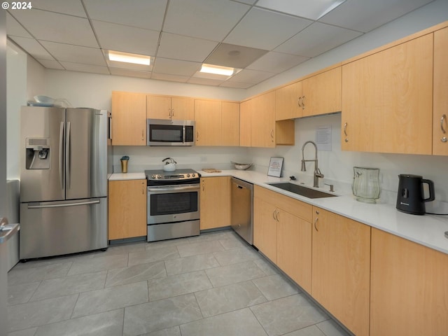 kitchen featuring a paneled ceiling, light brown cabinets, stainless steel appliances, and sink