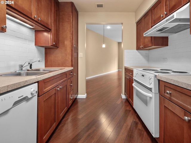 kitchen featuring white appliances, decorative light fixtures, sink, decorative backsplash, and dark hardwood / wood-style floors